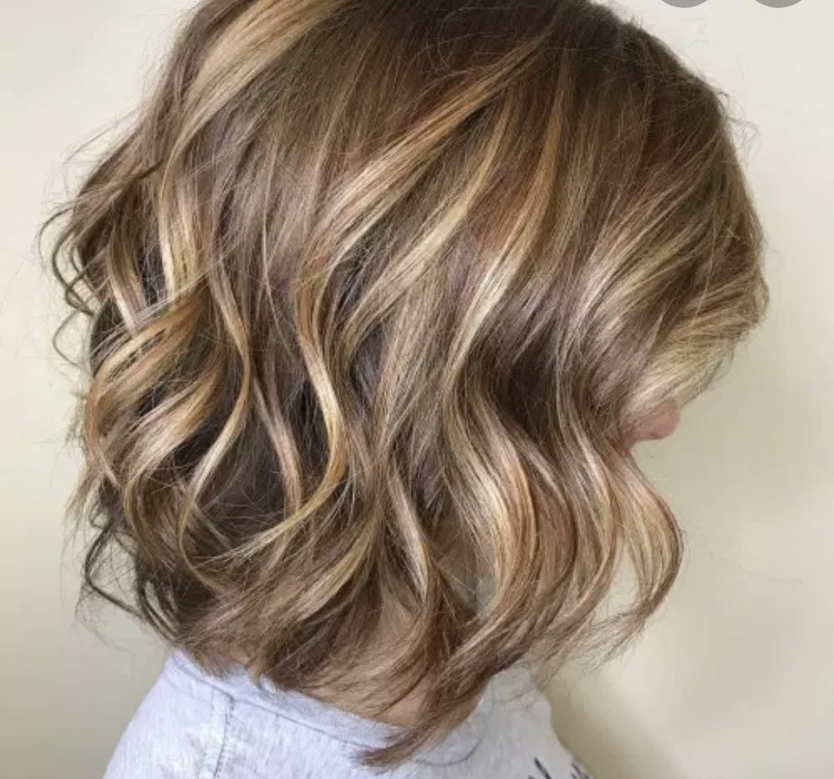 Blonde balayage on a wavy bob styled at Elegant Beauty Salon